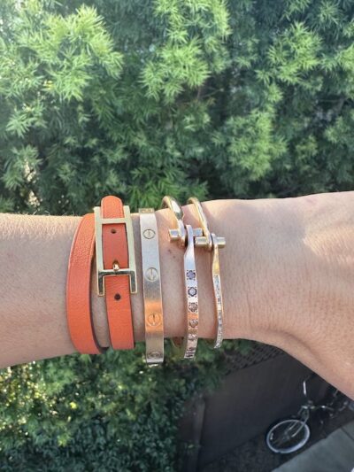 Tiffany mixes the Cartier Love Bracelet with a Hermes leather bracelet and two styles of Borgioni handcuff bracelets